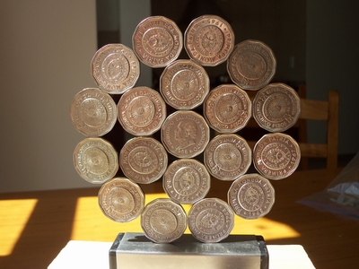 image: Standing hexagonal  rose / mandala of coins of  Argentina  (centre, r1, r2:  25 centavos 1965-67)          